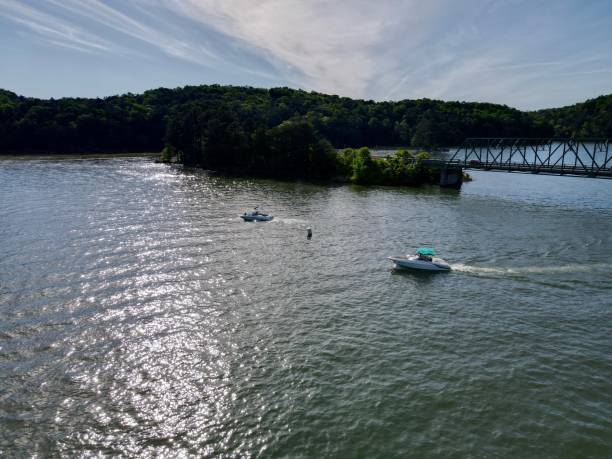 boats crossing under a bridge on a busy summer weekend - wake jet boat water water sport imagens e fotografias de stock