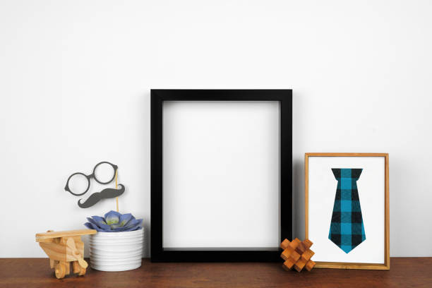 istock Mock up black frame with rustic Fathers Day decor on a wood shelf against a white wall 1315875486
