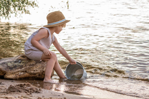 istock Boy pours water into the bucket 1315883175