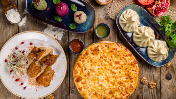 istock Khinkali with lamb, chachapuri with cheese megrelian, bean phali, beet phali, spinach phali, skewers of pork with onions and sauses top view on old wooden table, Georgian food 1315884391