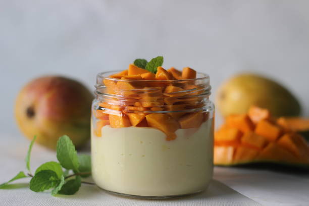 istock Vanilla custard topped with fresh cut mangoes served in a jar. 1315884575