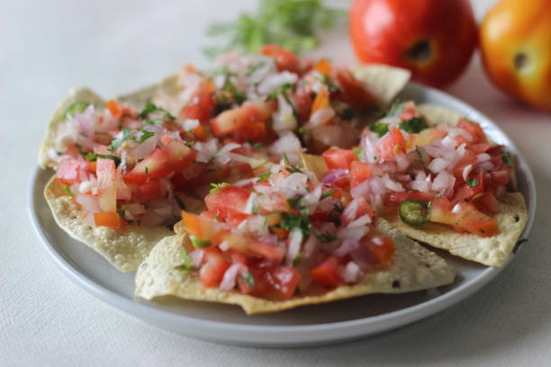 papados crujientes y fritos cubiertos con un relleno masala de cebollas, tomates y especias. popular entrante del norte de la india comúnmente conocido como masala papad. - fried onion roasted chopped fotografías e imágenes de stock