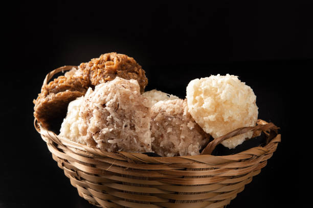 istock Cocada, Coconut candy from Brazil, white and brown cocadas in a straw basket on dark surface, black background, selective focus. 1315897910
