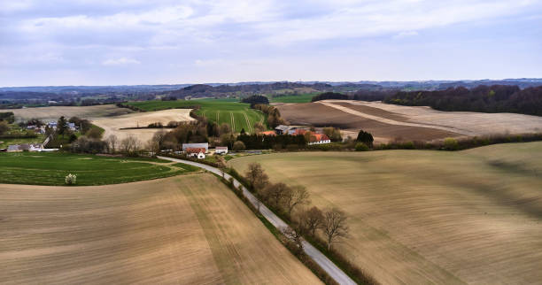 istock Single lane road through landscape and village 1315899587
