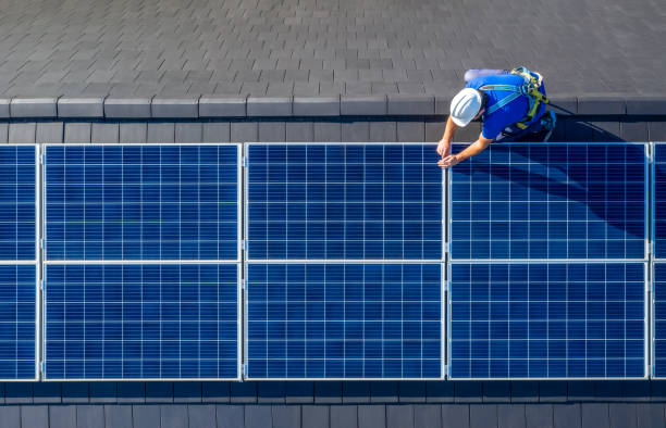 installatore di pannelli solari che installa pannelli solari sul tetto della casa moderna - pannelli solari foto e immagini stock
