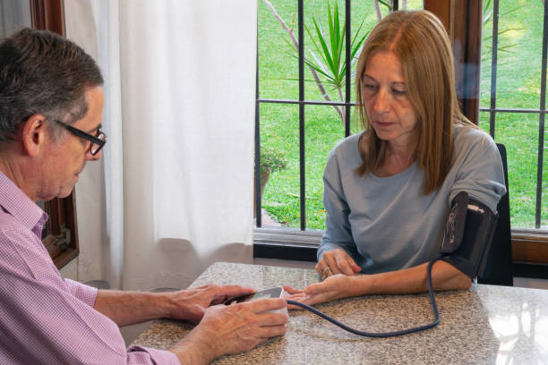 istock Man taking a woman 's blood pressure 1315905203