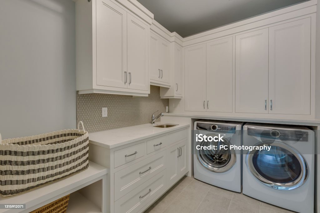 New laundry room with lots of space Top of the line washer and dryer and little sink to help clean clothes Utility Room Stock Photo