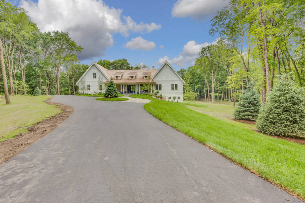 istock Long asphalt driveway in front of big house 1315912110