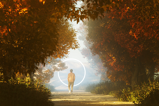 Young man walking towards mysterious portal on the forest road. 3D generated image.
