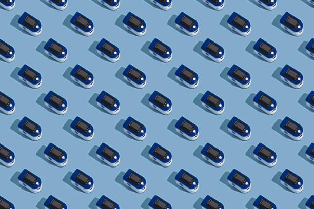 istock Portable pulse oximeter on a blue background with a hard shadow. Control of oxygen in the lungs. view from above.Pattern 1315917281