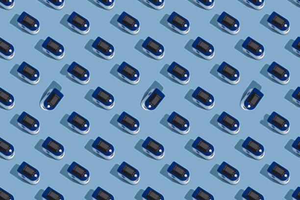istock Portable pulse oximeter on a blue background with a hard shadow. Control of oxygen in the lungs. view from above.Pattern 1315917288