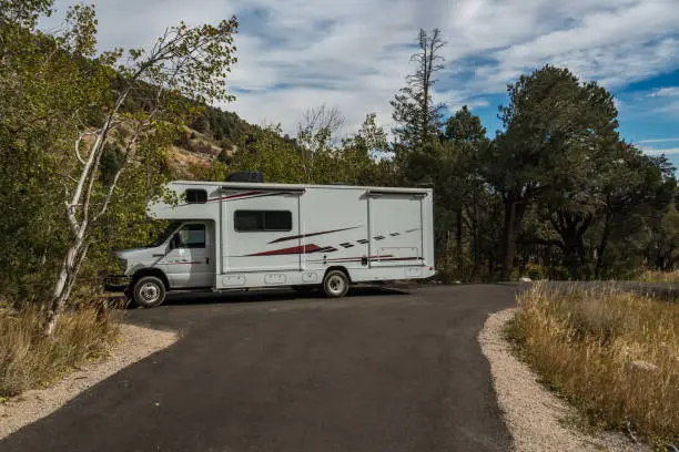 C-type camper with slideouts standing in a wilderness campground between the trees in the Great Basin National Park