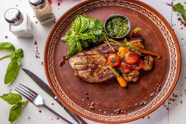 istock Pork entrecote served with grilled vegetables, mushrooms and pesto sauce, restaurant dish, Top view, Horizontal orientation 1315920708