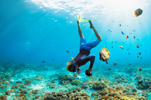 joven con máscara de snorkel se sumerge bajo el agua - nusa lembongan fotografías e imágenes de stock