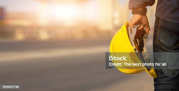 Engineer Holding Helmet On Site Road Construction For The Development Of Modern Transportation Systems Technician Worker Hold Hard Hat Safety First Stock Photo - Download Image Now