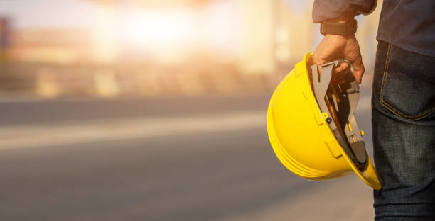 engineer holding helmet on site road construction for the development of modern transportation systems, technician worker hold hard hat safety first - construction worker imagens e fotografias de stock