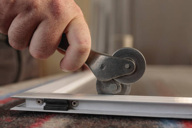 istock man's hand with a wheel tool to install a aluminum mosquito screen. Horizontal image. 1315937052