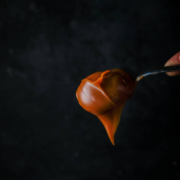 Argentine Sweet by Leche Argentinian Dulce de leche in a spoon presented for consumption dulce de leche stock pictures, royalty-free photos & images
