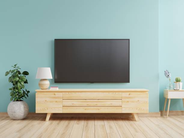 prendi in giro una parete tv montata in un soggiorno con una parete blu. - television stand foto e immagini stock