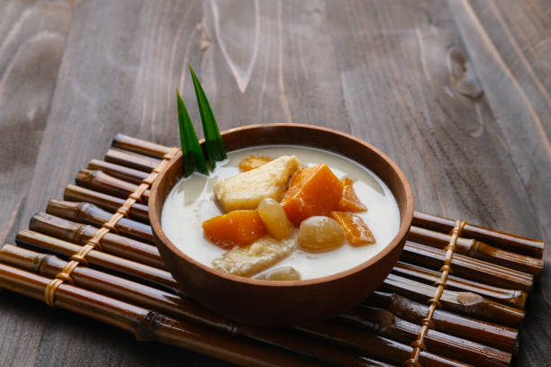 kolak oder kolak pisang ist ein indonesisches dessert, sehr beliebt bei ramadhan, hergestellt aus banane, kolang-kaling, süßkartoffel mit kokosmilch, palmzucker und pandanusblättern. - bamboo brown cooking gourmet stock-fotos und bilder