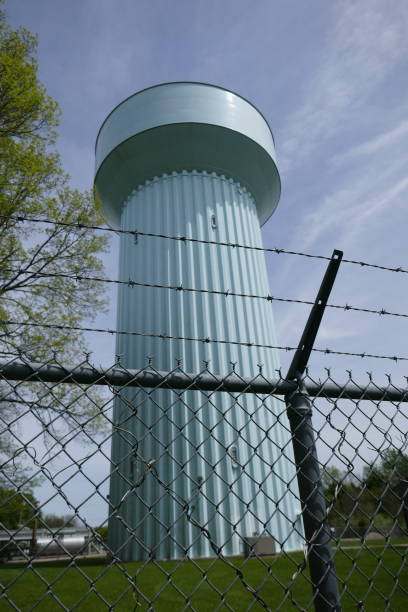 istock Barbed wire fence prohibiting entry to large blue water tower 1315946554