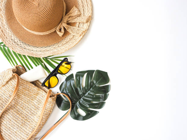 istock Summer accessories concept from sunglasses, straw hat and tropical palm leaf branches on white background with empty space for text. 1315956409