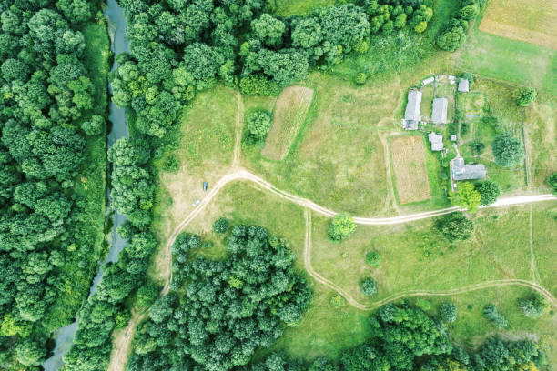 paesaggio estivo con agriturismo in una zona rurale accanto a una foresta e un fiume. foto drone aereo - house wood dirt road footpath foto e immagini stock
