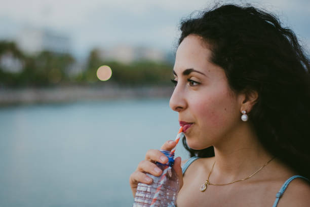 Midsection Of Woman Drinking Water At Restaurant