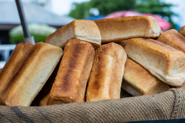 свежий печеный хлеб слева продаются на местном рынке уличной еды на острове занзибар, танзания, африка, крупным планом - africa agriculture zanzibar industry стоковые фото и изображения