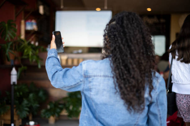 istock Over shoulder woman holding smart phone looking at screen 1315968175