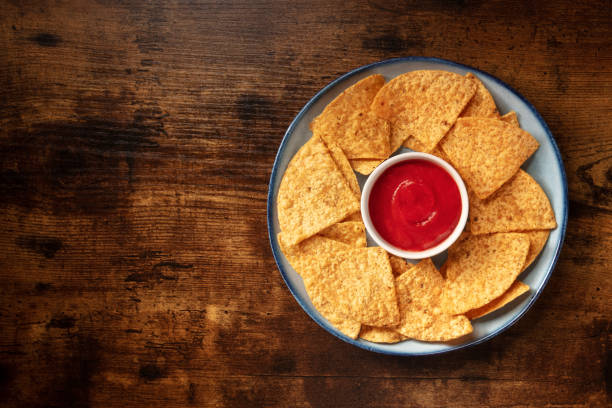 istock Nachos with tomato sauce, top shot on a rustic wooden table 1315969332