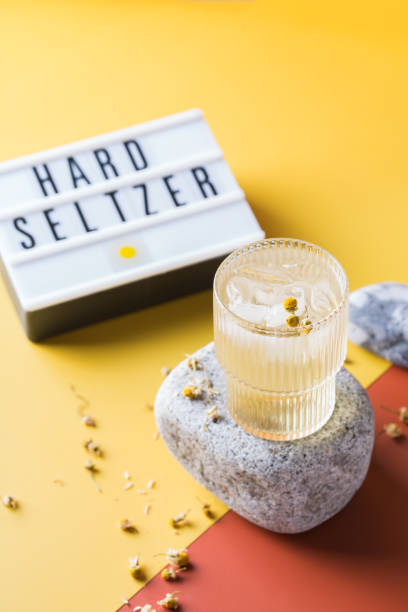 Hard seltzer cocktail with chamomile and ice Hard seltzer cocktail with chamomile and ice on a table. Summer refreshing beverage, drink soda water glass lemon stock pictures, royalty-free photos & images