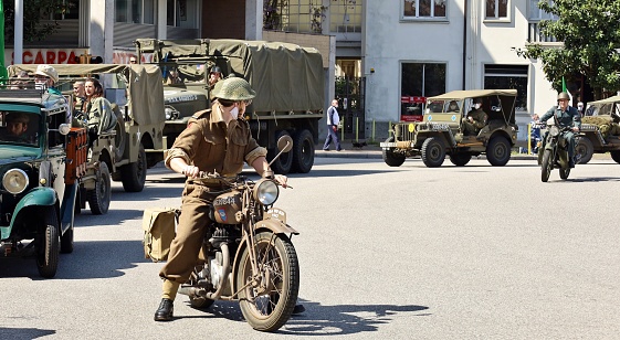Udine, Italy. May 1, 2021. British soldier on a motorcycle in front of column of Allied military vehicles , during a reenactment of the Second World War in the city.