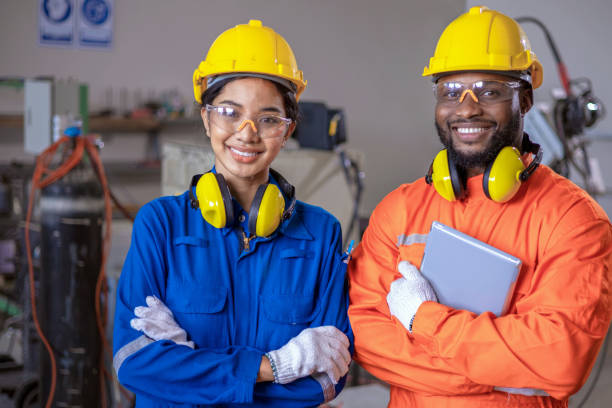 istock Engineer and Technician stood with crossed arms and smiling happiness in front of machine in factory. 1315973612