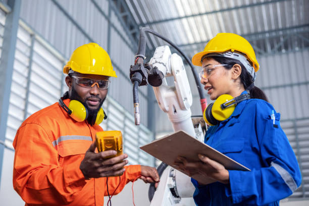 istock Female engineer and male technician discuss working problems of factory robots 1315973639