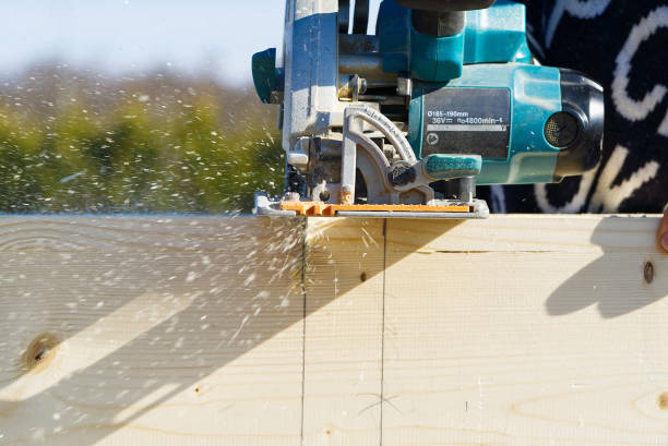 istock worker sawing wood board with electric circular saw. Carpenter working with a circular saw outside in sunny day. close-up 1315975868