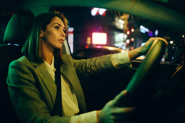 istock Young woman driving car alone at night. 1315976729