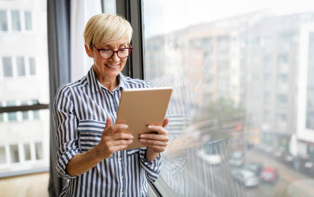 istock Attractive senior woman using a tablet computer relaxing at home 1315982759