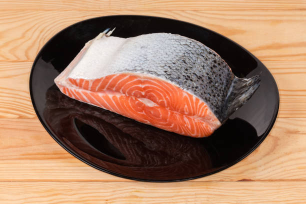 istock Piece of uncooked salmon on black dish on rustic table 1315984185