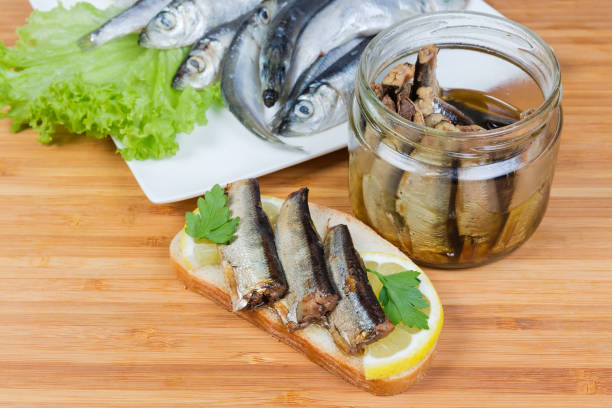 istock Open sandwich with preserved smoked sprats and jar with sprats 1315984231