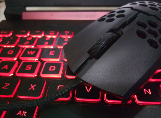 istock Perforated gaming mouse on the LED red gaming Keyboard 1315988459