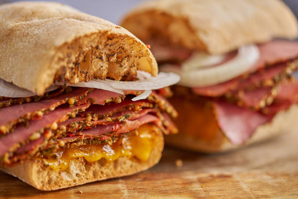 istock Thin cut pastrami sandwhich with delicious meet on baguette bread with chedder cheese, onion 1315992341