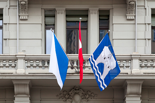 Flags of Zurich and Switzerland above a building entrance in the city center of Zurich.
