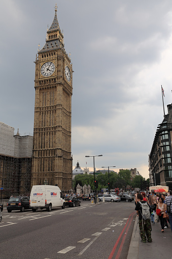 London, United Kingdom - June 05, 2010: Big Ben seen on a cloudy day during rush hour. There are cars on the street and there are many people on the sidewalks. It is one of the countless wonderful places that is a tourist attraction often visited by many tourists from all over the world.