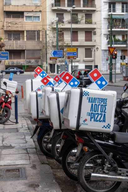 pionowy obraz pokazuje motocykle do dostawy pizzy słynnej restauracji domino.vertical image shows motorcycles for pizza delivery of the famous domino's restaurant. - dominos pizza zdjęcia i obrazy z banku zdjęć