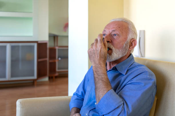 istock Photo of a Sick Older Man in the Bed with Asthmatic Problems. 1315999504