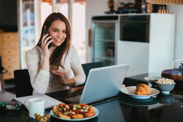 istock Woman using smartphone and laptop working from home 1316001740