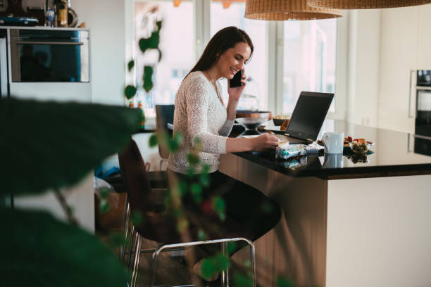 istock Woman using smartphone and laptop working from home 1316001909