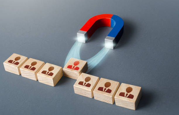 istock Magnet pulls a red employee out of row blocks. Hiring best candidate. Poaching participants from other company. Luring concept. Selection for a management position on a competitive basis. 1316003123