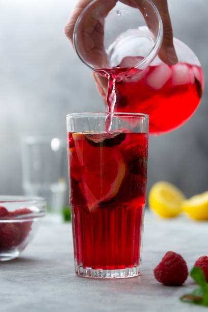 istock Pouring raspberries cold drink with lemon, mint and berries. Homemade cocktail. 1316005174